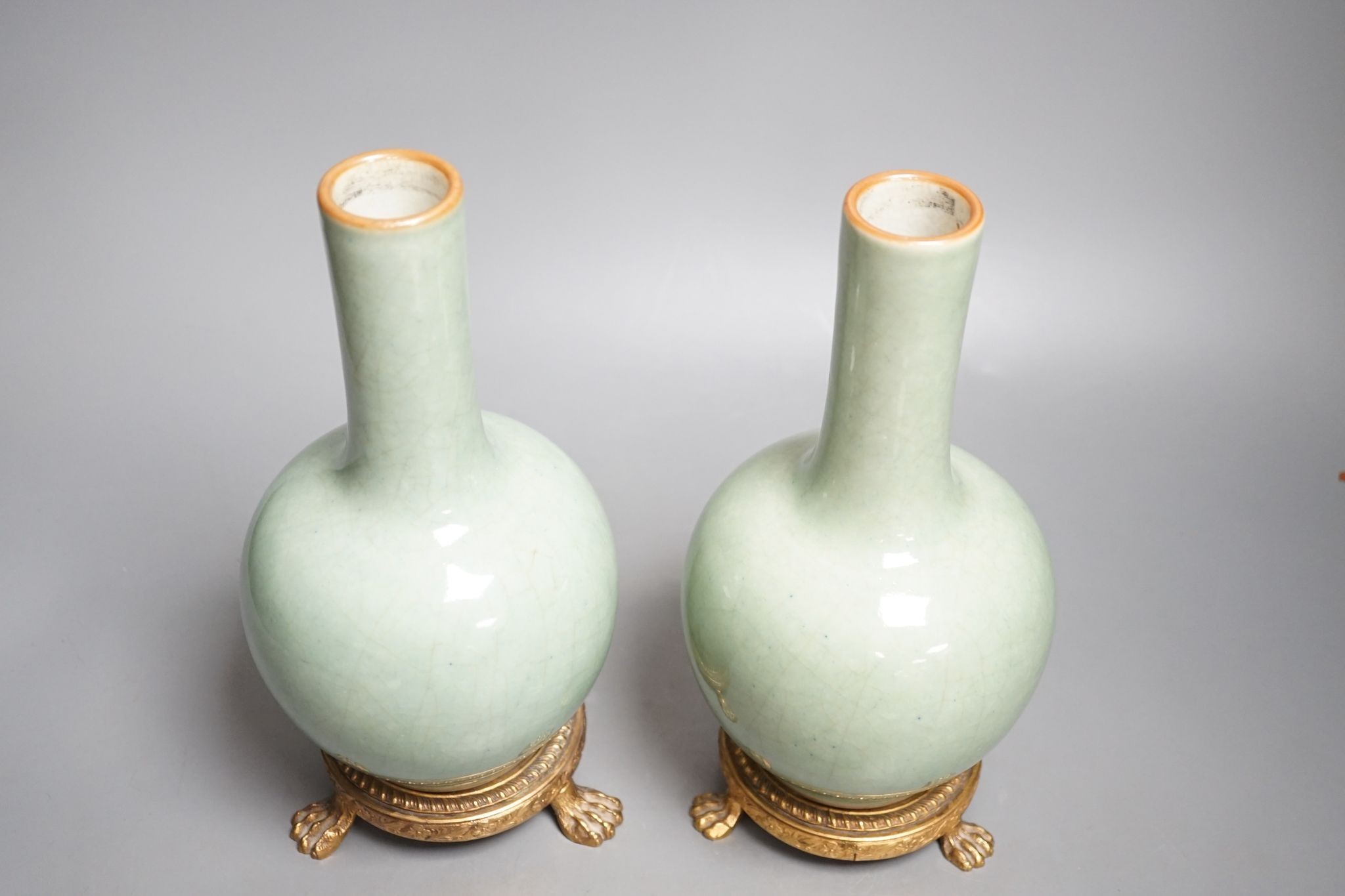 A pair of Chinese celadon crackle glazed bottle vases with gilt metal stands total height 27cm, bases drilled